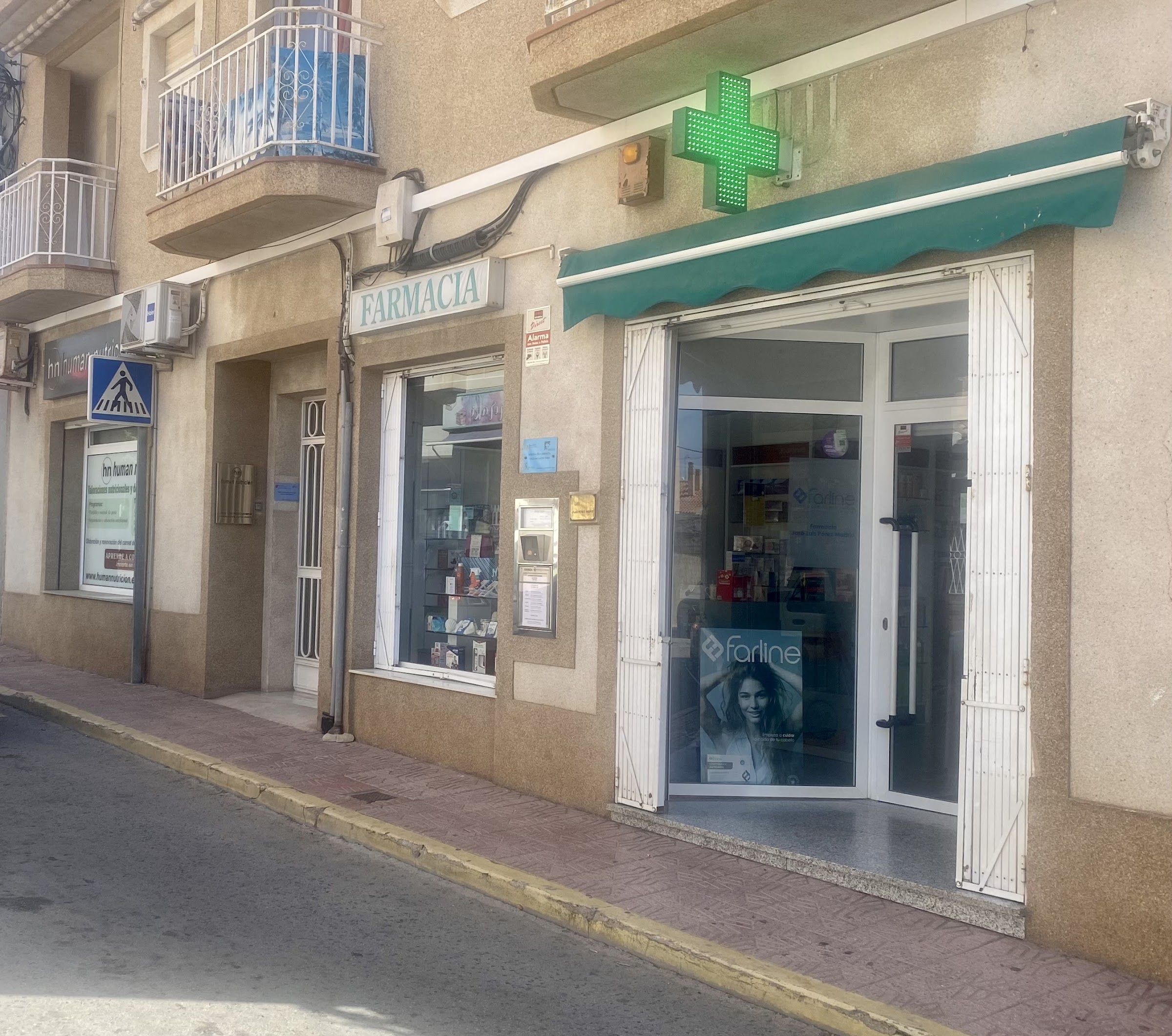Fachada de la Farmacia Pérez Madrid con su cruz verde, en el Puerto de Mazarrón